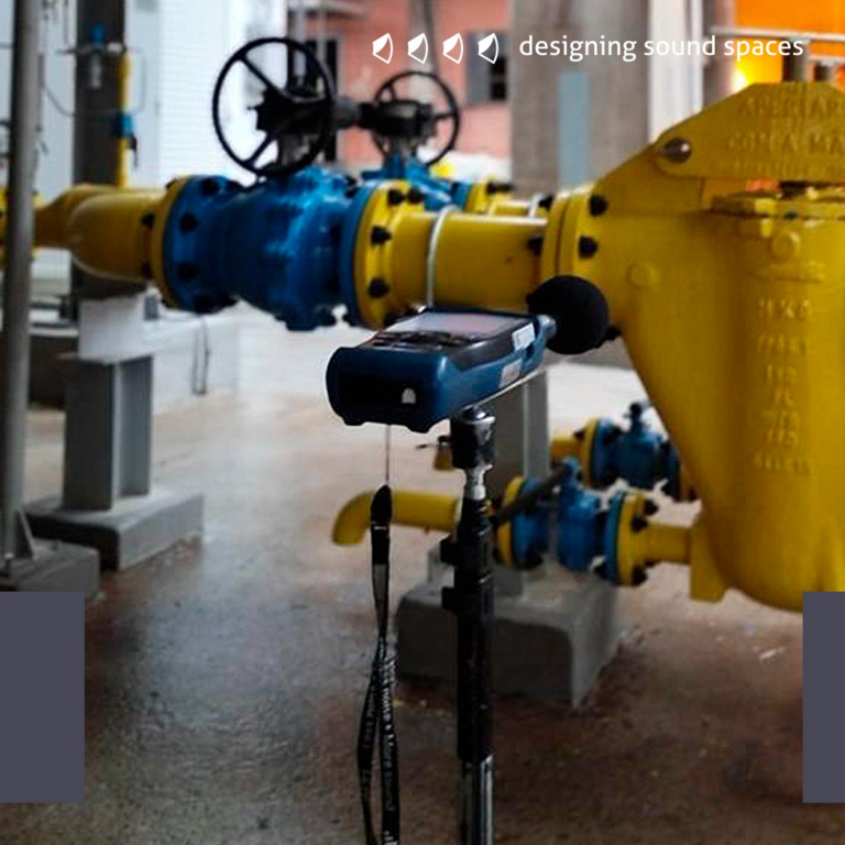 Imagem do Post - Sonômetro azul posicionado em frente a um equipamento industrial